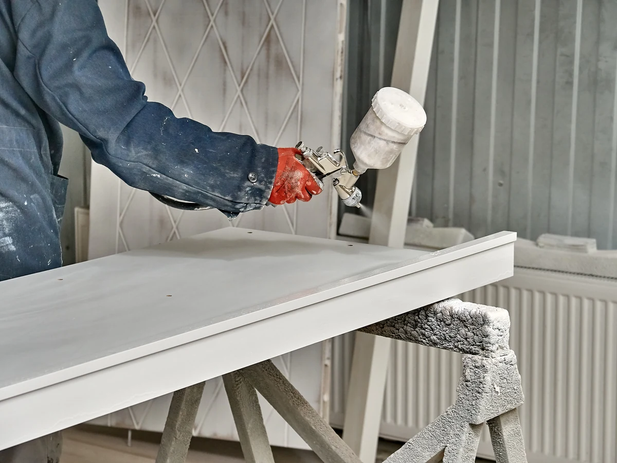 Painter spraying white paint in Hampstead, decorating worker by Hampstead Decorators