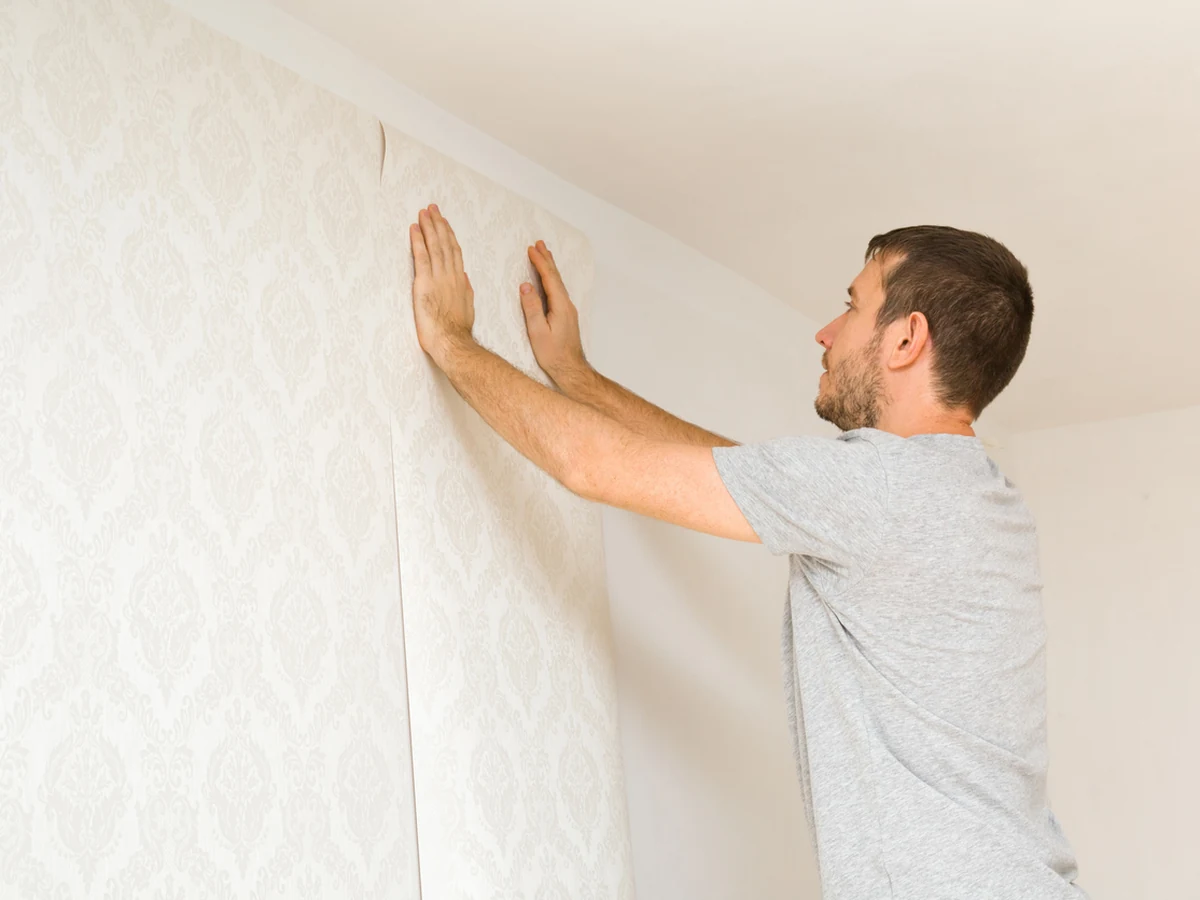 Man pressing patterned wallpaper in Hampstead, wallpapering services by Hampstead Decorators